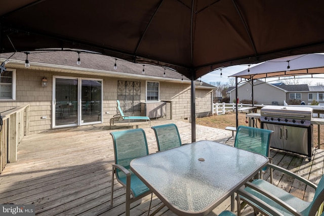 wooden deck with area for grilling and a gazebo