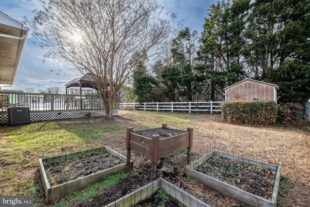 view of yard featuring a storage shed, a gazebo, central AC, and a wooden deck