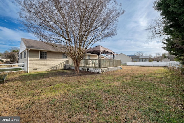 exterior space with a yard, a gazebo, central air condition unit, and a wooden deck