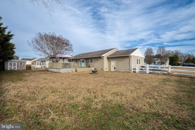 rear view of property featuring a gazebo, a yard, and a storage unit