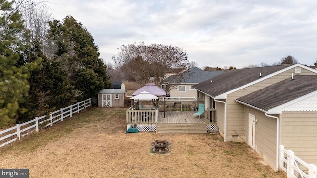 exterior space featuring a fire pit, a storage shed, a gazebo, and a deck