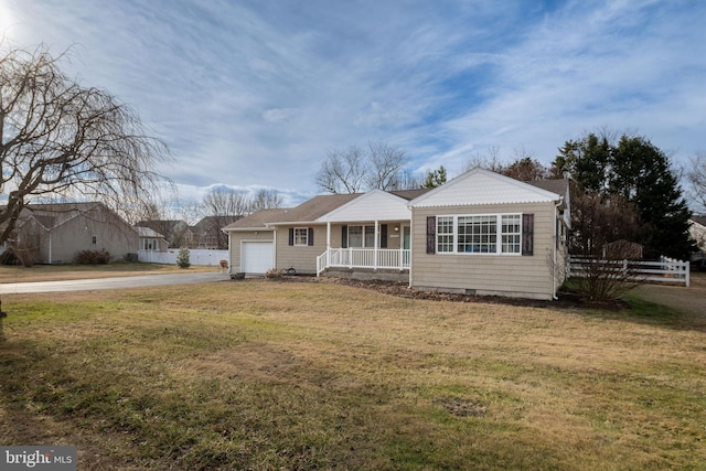 ranch-style home with a garage, a front yard, and covered porch