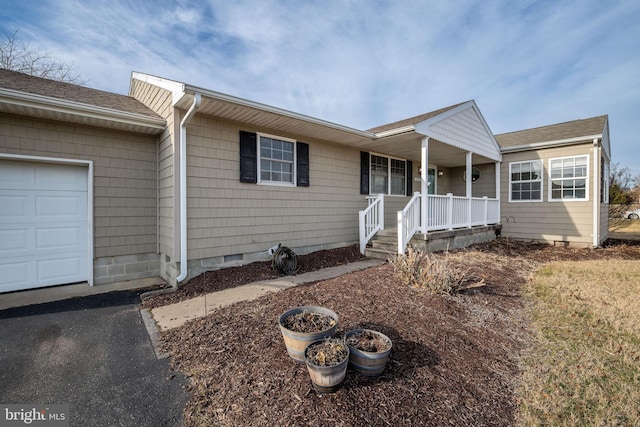 ranch-style home featuring a garage and covered porch