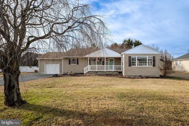 ranch-style home featuring a garage, covered porch, and a front lawn