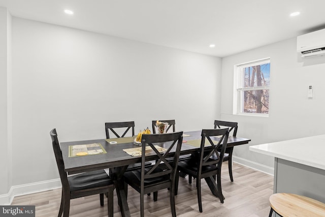 dining space with light hardwood / wood-style flooring and an AC wall unit