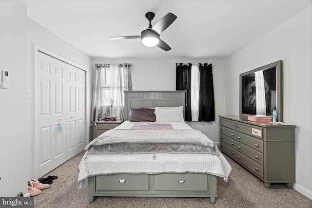 bedroom with ceiling fan, light carpet, and a closet