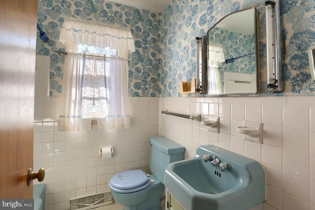 bathroom featuring tile walls, sink, and toilet