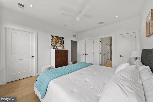 bedroom with ceiling fan, connected bathroom, and light hardwood / wood-style flooring