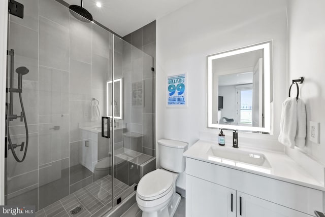 bathroom with vanity, a shower with shower door, and toilet