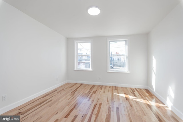 empty room featuring baseboards and wood finished floors