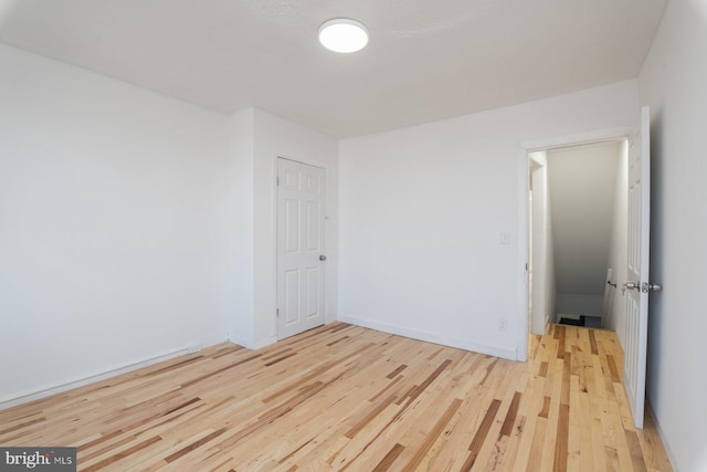 unfurnished room with wood finished floors and baseboards