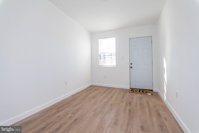 unfurnished room with baseboards and light wood finished floors