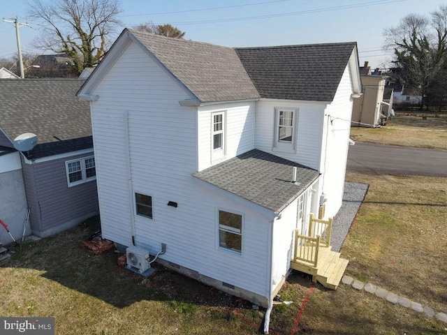 back of property with ac unit and a yard