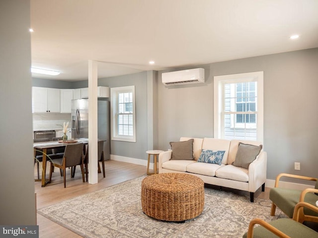 living room featuring light hardwood / wood-style floors and an AC wall unit