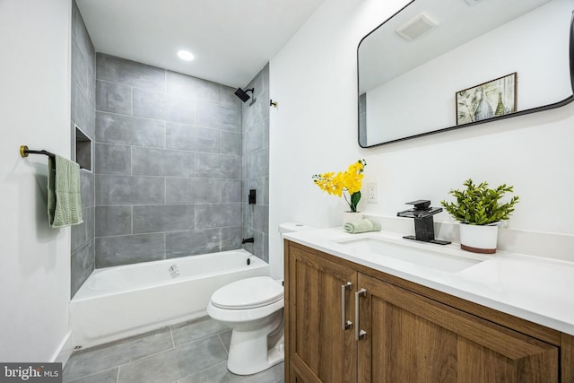 full bathroom featuring tile patterned flooring, tiled shower / bath, vanity, and toilet