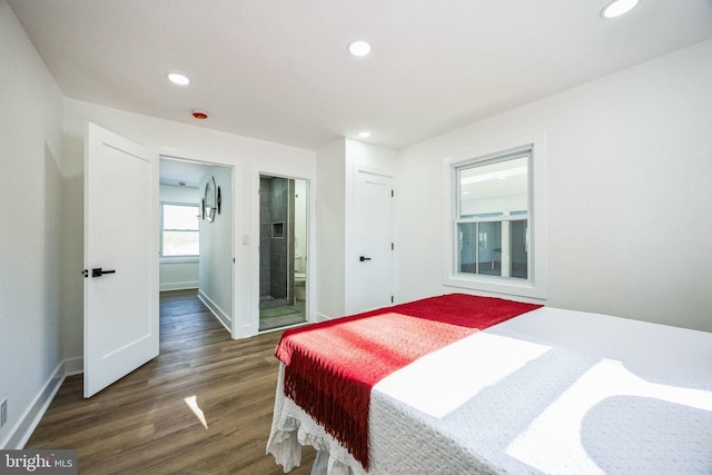 bedroom with dark hardwood / wood-style flooring and ensuite bath