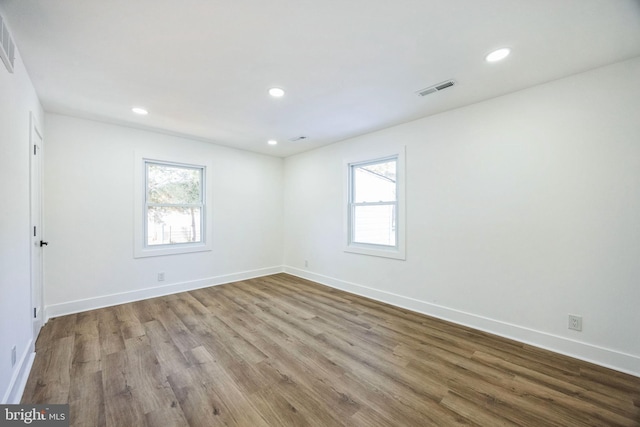 empty room with light hardwood / wood-style flooring and a wealth of natural light