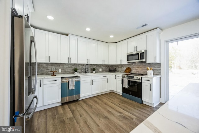 kitchen featuring white cabinetry, sink, wood-type flooring, and stainless steel appliances