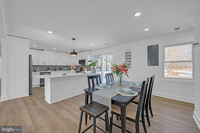 dining room featuring light hardwood / wood-style flooring and electric panel