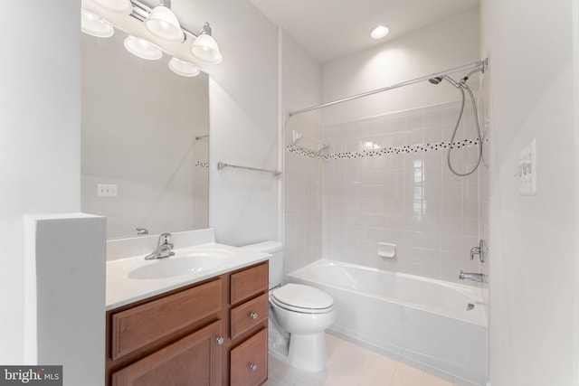 full bathroom featuring tiled shower / bath, vanity, and toilet