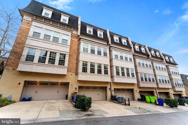 view of front of property with a garage and central AC unit