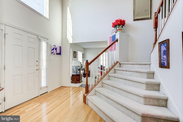 foyer featuring hardwood / wood-style flooring and a towering ceiling