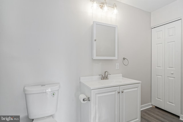 bathroom with vanity, wood-type flooring, and toilet