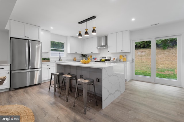 kitchen featuring stainless steel appliances, white cabinetry, a kitchen island, and a kitchen bar