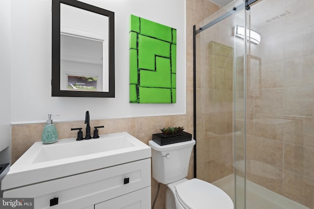 bathroom featuring vanity, tile walls, an enclosed shower, and toilet