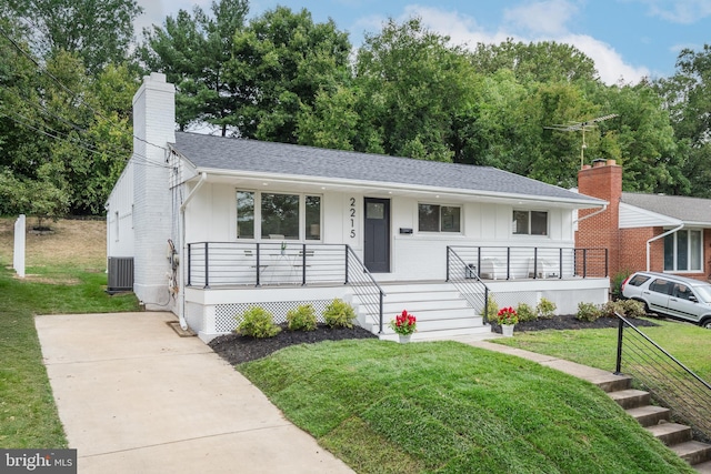 ranch-style house featuring a porch, central air condition unit, and a front lawn