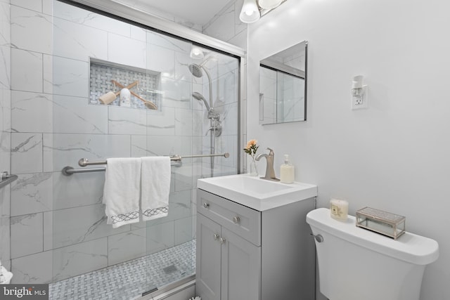 bathroom with vanity, a shower with door, and toilet