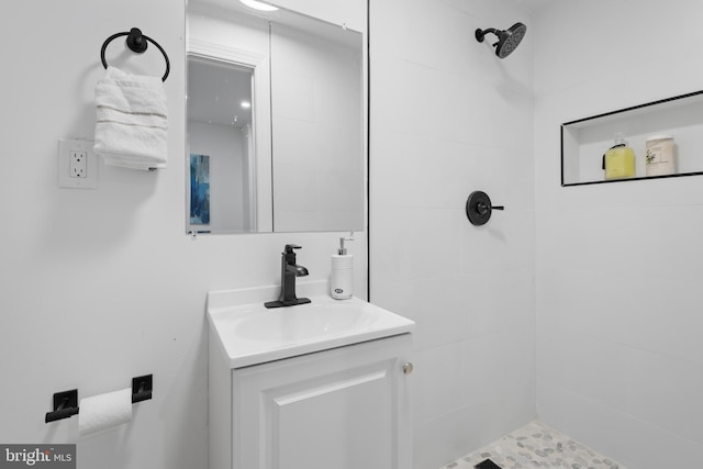 bathroom featuring tiled shower and vanity