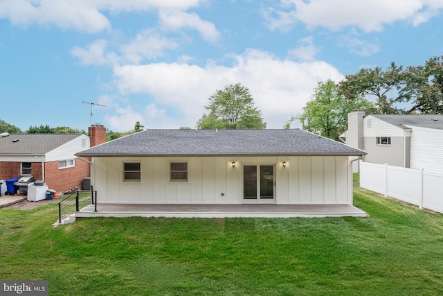 rear view of property featuring a patio and a lawn