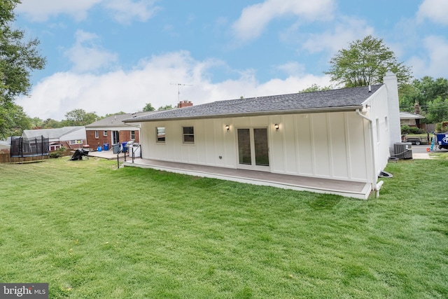 rear view of house featuring a trampoline, a yard, and a patio area