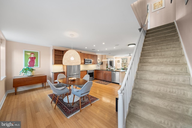 dining space with sink and light wood-type flooring