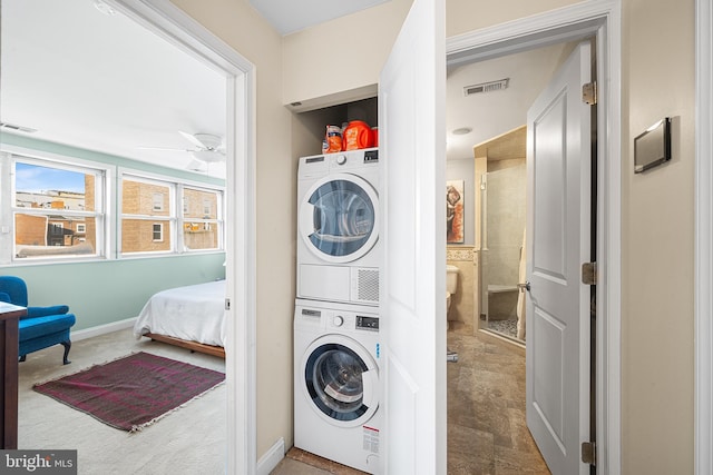 clothes washing area with stacked washer and dryer and ceiling fan