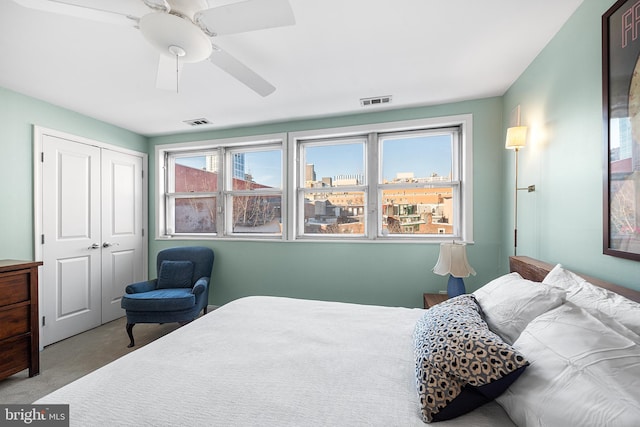 carpeted bedroom featuring ceiling fan and a closet