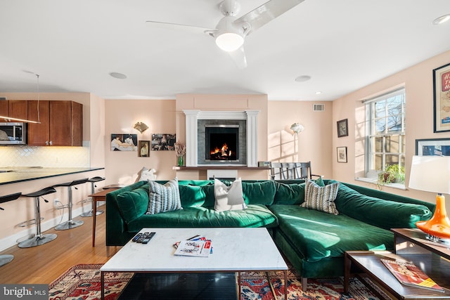 living room featuring hardwood / wood-style flooring and ceiling fan