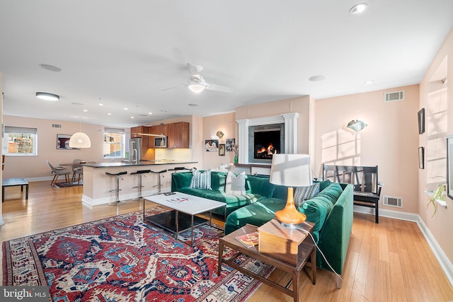 living room featuring light hardwood / wood-style floors and ceiling fan