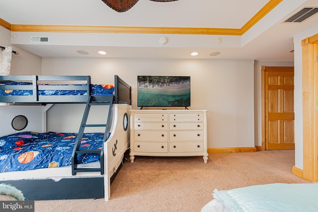 carpeted bedroom featuring ornamental molding and a tray ceiling