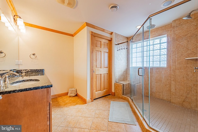 bathroom featuring crown molding, vanity, a shower with door, and tile patterned flooring