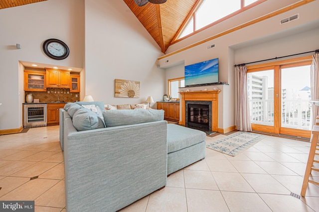 living room featuring bar area, lofted ceiling, beverage cooler, light tile patterned floors, and wooden ceiling