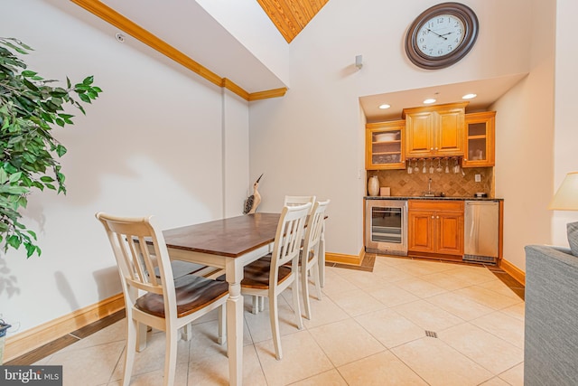 tiled dining room with high vaulted ceiling, wet bar, and beverage cooler