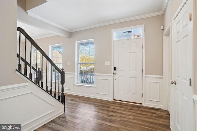 foyer with ornamental molding and dark hardwood / wood-style floors