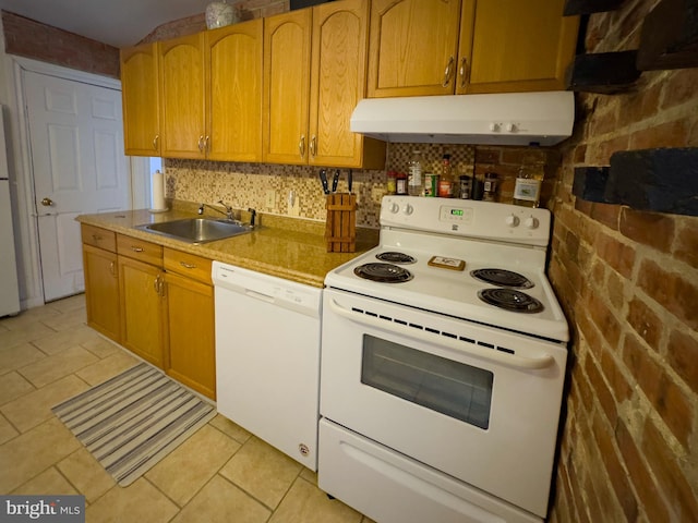 kitchen featuring light tile patterned floors, tasteful backsplash, a sink, white appliances, and under cabinet range hood