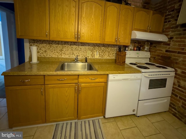 kitchen with under cabinet range hood, brick wall, white appliances, a sink, and decorative backsplash