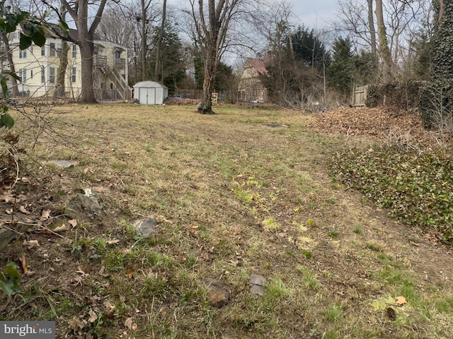 view of yard with a storage unit, an outdoor structure, and fence