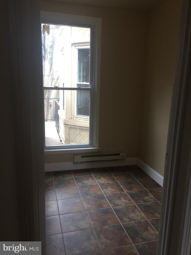 unfurnished room with a baseboard heating unit