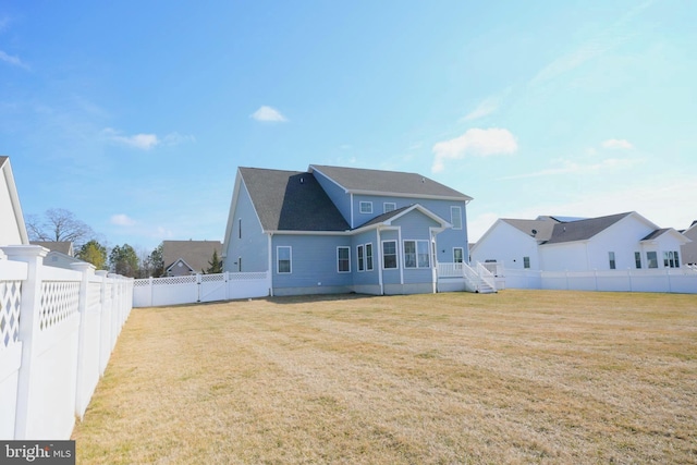 rear view of house featuring a lawn