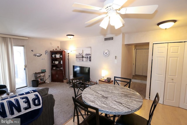 carpeted dining area featuring ceiling fan